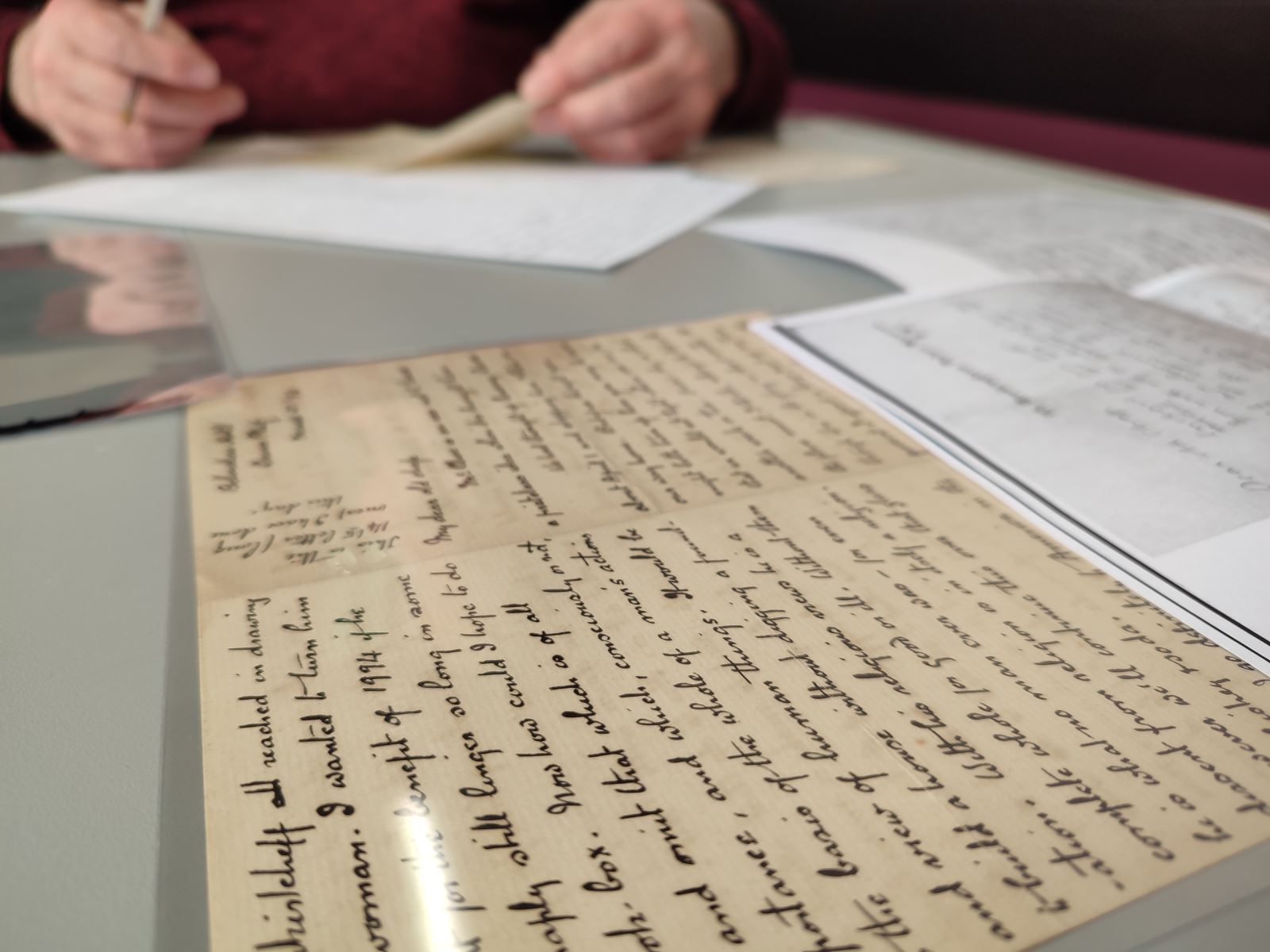 A person writing out a copy of a letter from the Conan Doyle Collection
